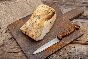 Smoked pork fat with spices on wooden board. Salted salo