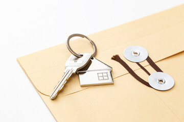 白背景に紐付き封筒と家の鍵