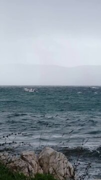 Motorboat moving on the disquiet wavy sea surface near Njivice, Croatia. One day after Storm Ciar&aacute;n - also called Emir - smashed into Krk Island with strong winds and driving rain.