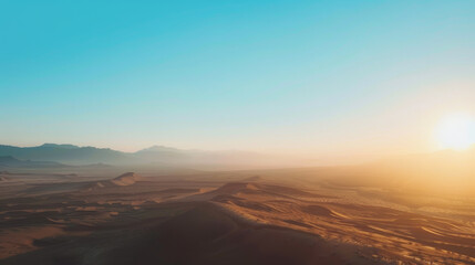Fototapeta na wymiar Sunrise over desert dunes with distant mountains