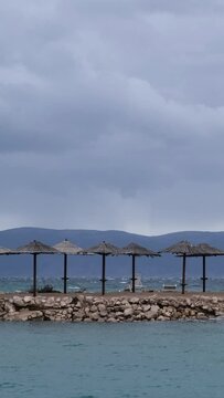 Powerful waves crashing the coast of Njivice, Croatia one day after Storm Ciar&aacute;n smashed into Krk Island. Beautiful disquiet blue sea surface on a rainy day. Cinematic water splashes.