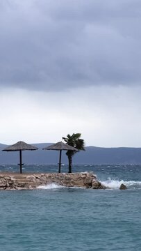 Slow motion of waves crashing the coast of Njivice, Croatia one day after Storm Ciar&aacute;n smashed into Krk Island. Beautiful disquiet blue sea and water splashes surface on a rainy day.