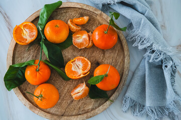 Mandarins with green leaves on a wooden tray