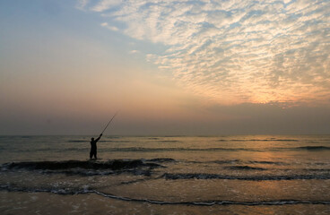 fishing on the beach at sunset, leisure activity during holidays 