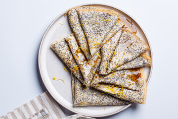 Crepes with poppy seeds, maple syrup and zest.