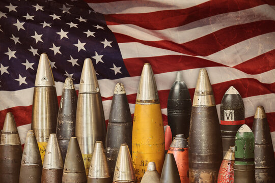 Military bombs and ammunition in front of a waving American flag
