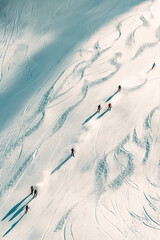 View from above of skiers skiing down a ski slope