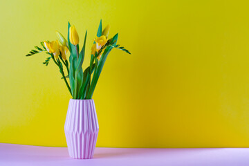 bouquet of yellow tulips in a vase on a yellow background
