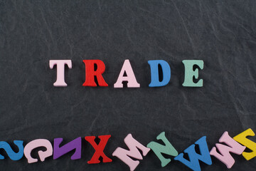 TRADE word on black board background composed from colorful abc alphabet block wooden letters, copy space for ad text. Learning english concept.