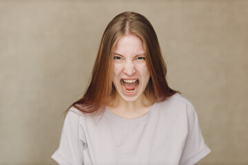 Portrait of shout screaming young caucasian woman looking at camera against beige background. Casting film movie acting auditions. - 767208818