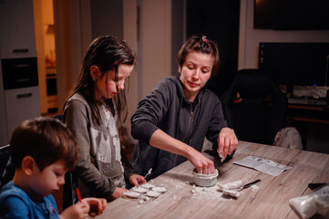 A trio of siblings are immersed in creative play, with the oldest guiding the younger ones in a fun...