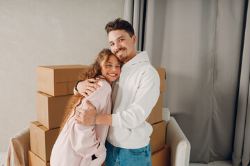 Happy young family couple man and woman hugging and moving with cardboard boxes to new estate home apartment. - 767210682