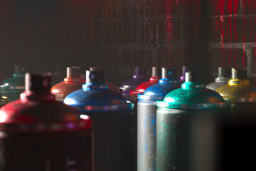 Array of Colorful Spray Paint Cans Illuminated Against a Dark Background