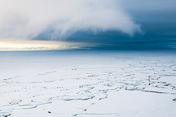 Melting ice on Baikal lake in spring. Clouds over the lake at sunrise. Baikal lake, Siberia, Russia.