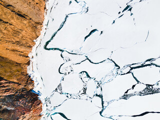 Melting ice on the shore of Baikal lake in spring. Aerial top down view.