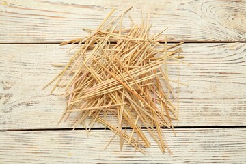 Heap of dried hay on white wooden background, flat lay