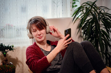 A woman laughs delightfully as she browses her smartphone, enjoying the perfect blend of good tunes...