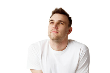 Young dreaming man with short brunette hair looking up dressed white t-shirt against white studio background. Concept of natural beauty, spa treatments, masculine, cosmetology.