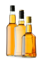 Different sorts of whiskey in glass bottles isolated on white