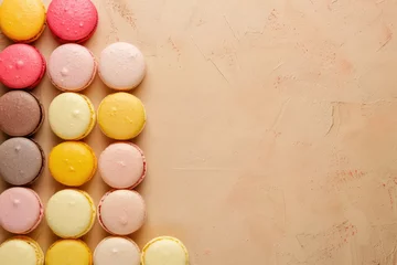 Fototapeten colorful french macarons lined up on neutral background with copy space © Klay