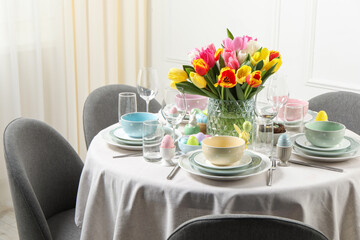 Easter celebration. Festive table setting with beautiful flowers and painted eggs