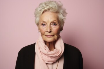 Portrait of an elderly woman with a pink scarf on a pink background