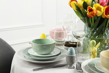 Easter celebration. Festive table setting with beautiful flowers and painted eggs