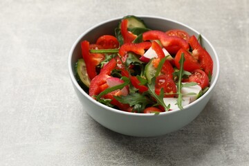 Tasty fresh vegetarian salad on light grey table
