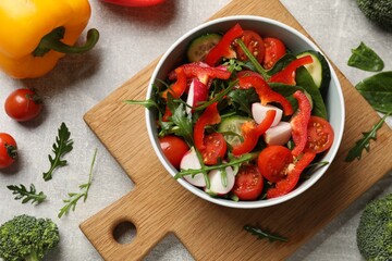 Tasty fresh vegetarian salad on light grey table, flat lay