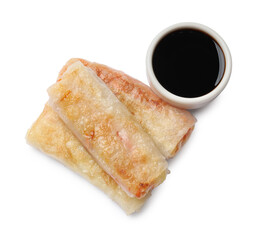 Delicious fried spring rolls and sauce isolated on white, top view