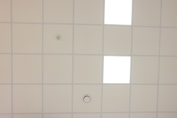 White ceiling with PVC tiles and lighting, bottom view