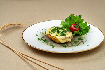 Baked potatoes with cheese and herbs on a plate