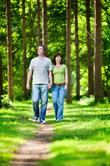 Life begins at 40. A mature couple enjoying time together as they enjoy the warm summer weather in a sunny woodland park.