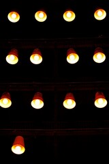 series of illuminated lights in rows against a dark background, 13 lamps. concepts: patterns in...