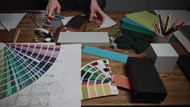 Working in a design studio. Interior designers are working with various palettes, textures, and material samples to select combinations for their project.
