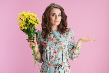stylish female in floral dress shrugging on pink