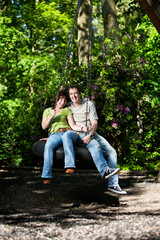 Life begins at 40. A young-at-heart mature couple in a carefree mood enjoying each others company while sharing a swing.