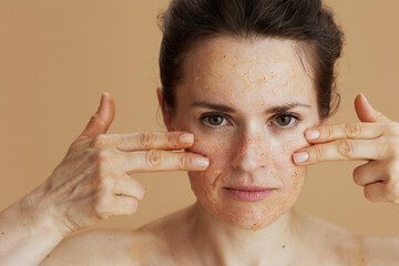 woman with face scrub on beige background - 767225605