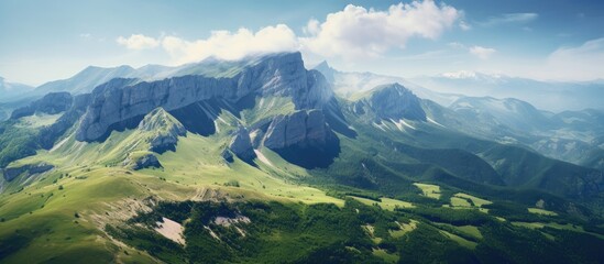 A sweeping vista of a mountain range and sparse green hills - Powered by Adobe