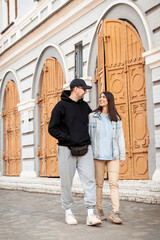 Portrait of a happy young couple walking along a city street.