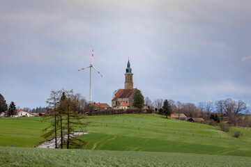 Katholische Kirche St. Michael Alxing/Bruck in Bayern mit Windrad zur Stromgewinnung