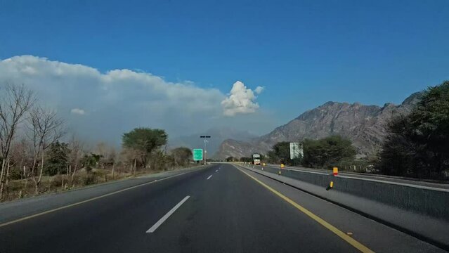 driving on the highway and clouds, blue sky in front while traveling on asphalt road
