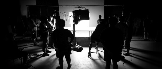 Silhouette images of video production behind the scenes of making of TV commercial movie shoot that...
