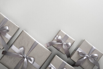 Monochrome gray gift boxes with gray ribbons on light background. Place for your text.