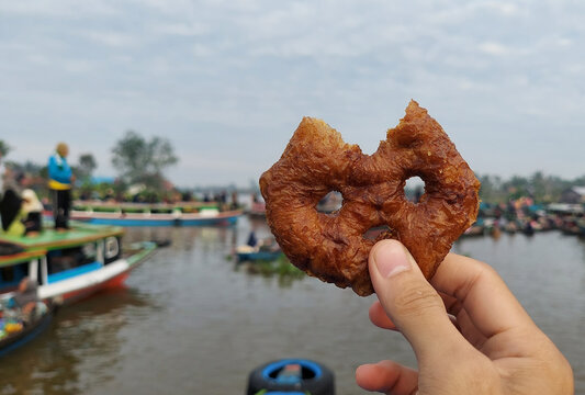 A piece of Ring Cake (Wadai Cincin) that has been bitten with blurred background at Lok Baintan Floating Market, Martapura