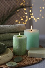 Spa composition. Burning candles, stones, soap and towels on grey table