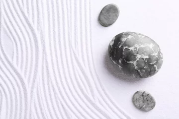 Fototapeten Zen garden stones on white sand with pattern, flat lay © New Africa