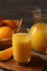 Tasty fresh oranges and juice on wooden table, closeup