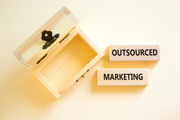 Outsourced marketing symbol. Concept words Outsourced marketing on beautiful wooden blocks....