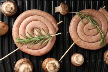Homemade sausages, rosemary and mushrooms on electric grill, top view